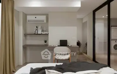 Modern bedroom with study area and in-unit laundry, featuring sleek design and neutral tones.