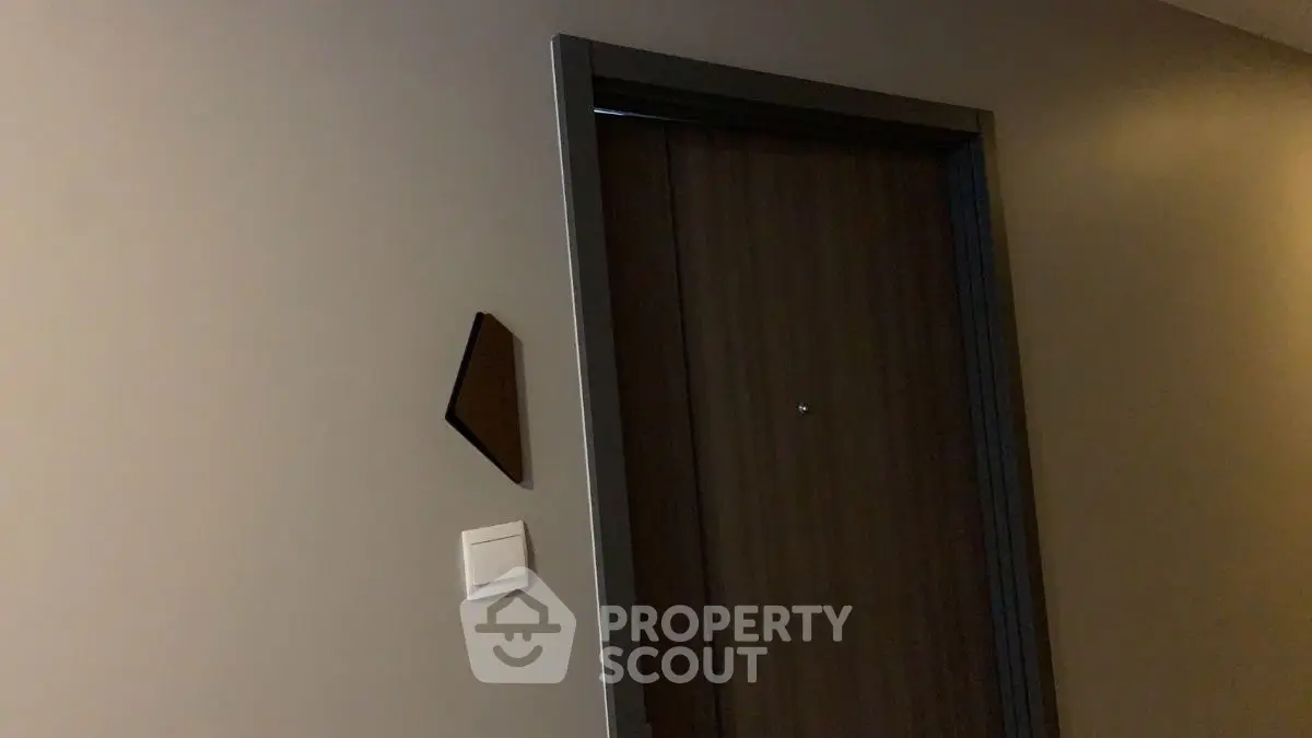 Modern apartment entrance with sleek wooden door and minimalist design.