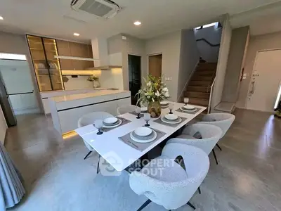 Modern dining area with elegant table setting and stylish kitchen in open layout design.