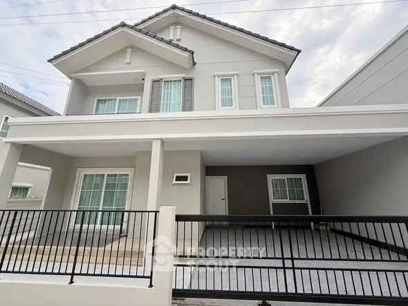 Modern two-story house with spacious driveway and sleek design.