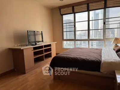 Spacious bedroom with city view, featuring a large window, wooden flooring, and modern furnishings.