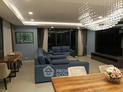 Luxurious living room with elegant chandelier and plush blue sofas