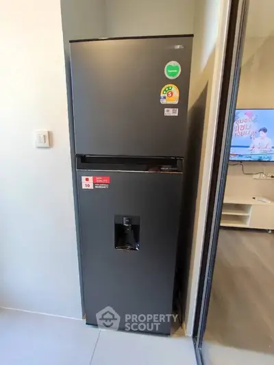 Modern kitchen with sleek black refrigerator and sliding glass door