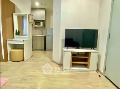 Modern living room with TV and kitchenette in cozy apartment