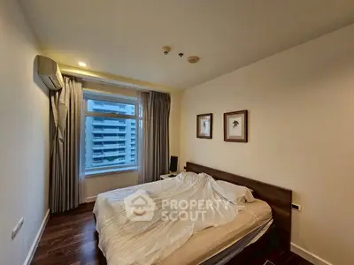 Cozy bedroom with modern decor and city view, perfect for urban living.