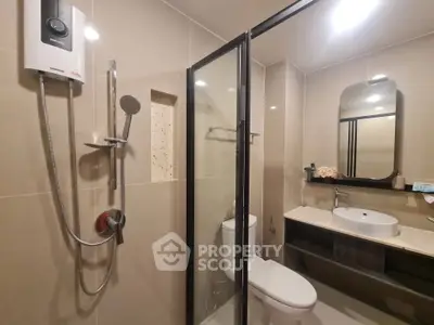Modern bathroom with glass shower and sleek fixtures in a contemporary home.