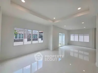 Spacious and bright living room with large windows and modern lighting