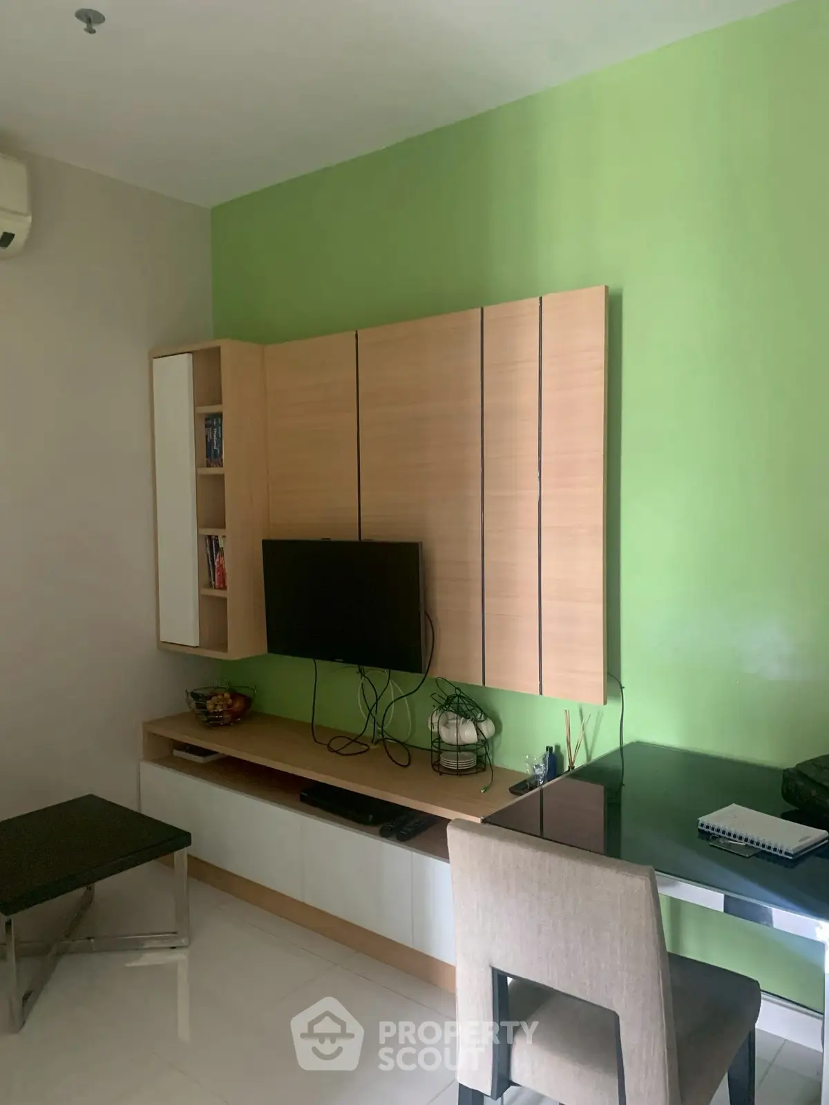 Modern living room with green accent wall and sleek wooden furniture