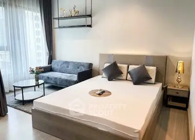 Modern bedroom with stylish decor and cozy seating area in a bright apartment.