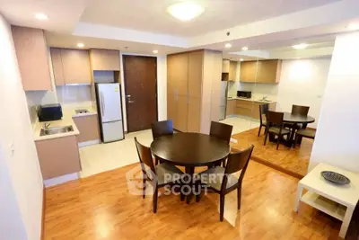 Spacious open-layout kitchen and dining area with modern furnishings and wooden flooring.