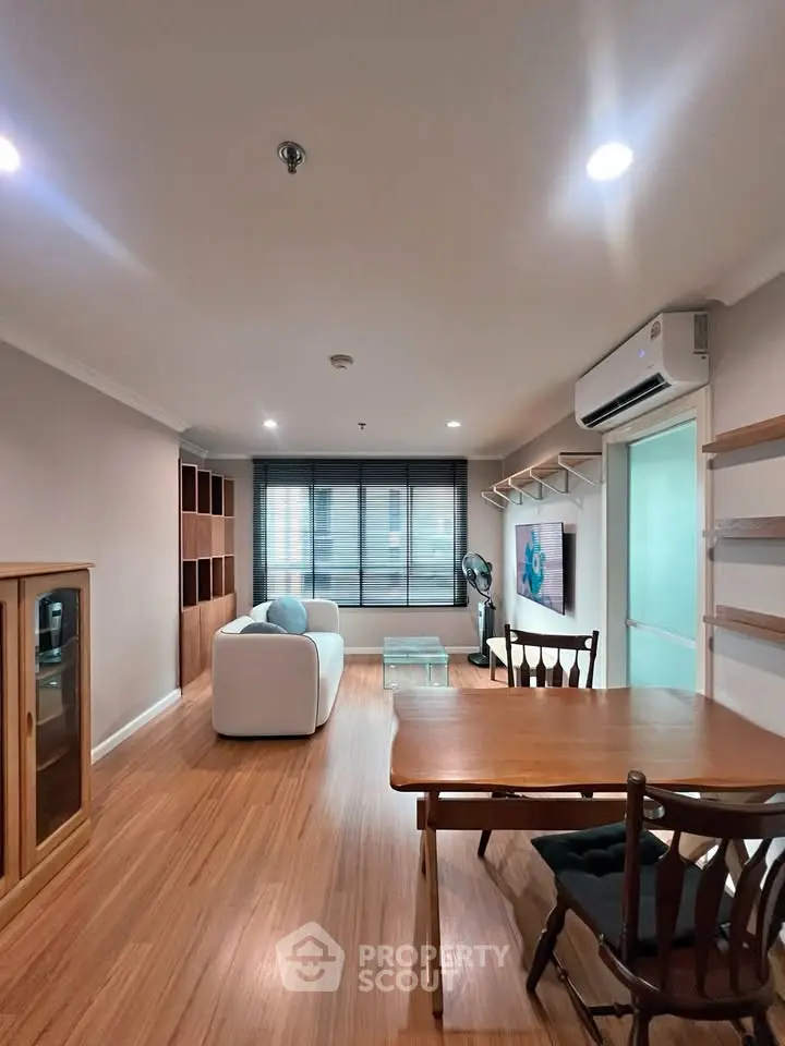 Spacious living room with modern furniture and wooden flooring, perfect for relaxation and entertainment.