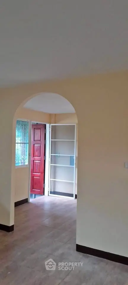 Spacious interior with archway and wooden door, ideal for modern living.