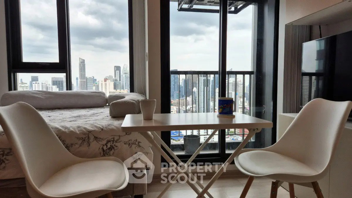 Modern apartment with stunning city view, cozy dining area, and large windows for natural light.