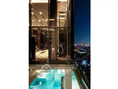Luxurious high-rise building with illuminated pool and stunning city view at night.