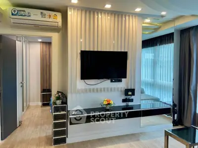Modern living room with sleek TV setup and stylish decor in a contemporary apartment.
