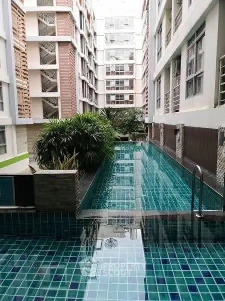 Luxurious apartment complex with a stunning swimming pool and modern architecture.