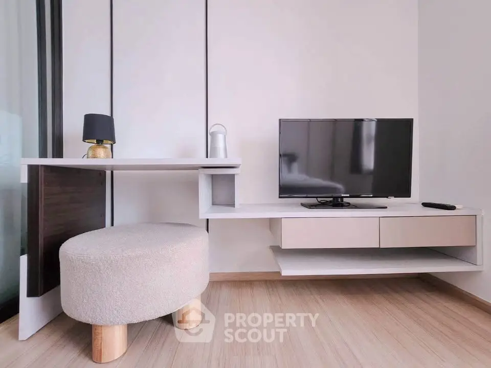 Modern living room with sleek TV stand and cozy ottoman
