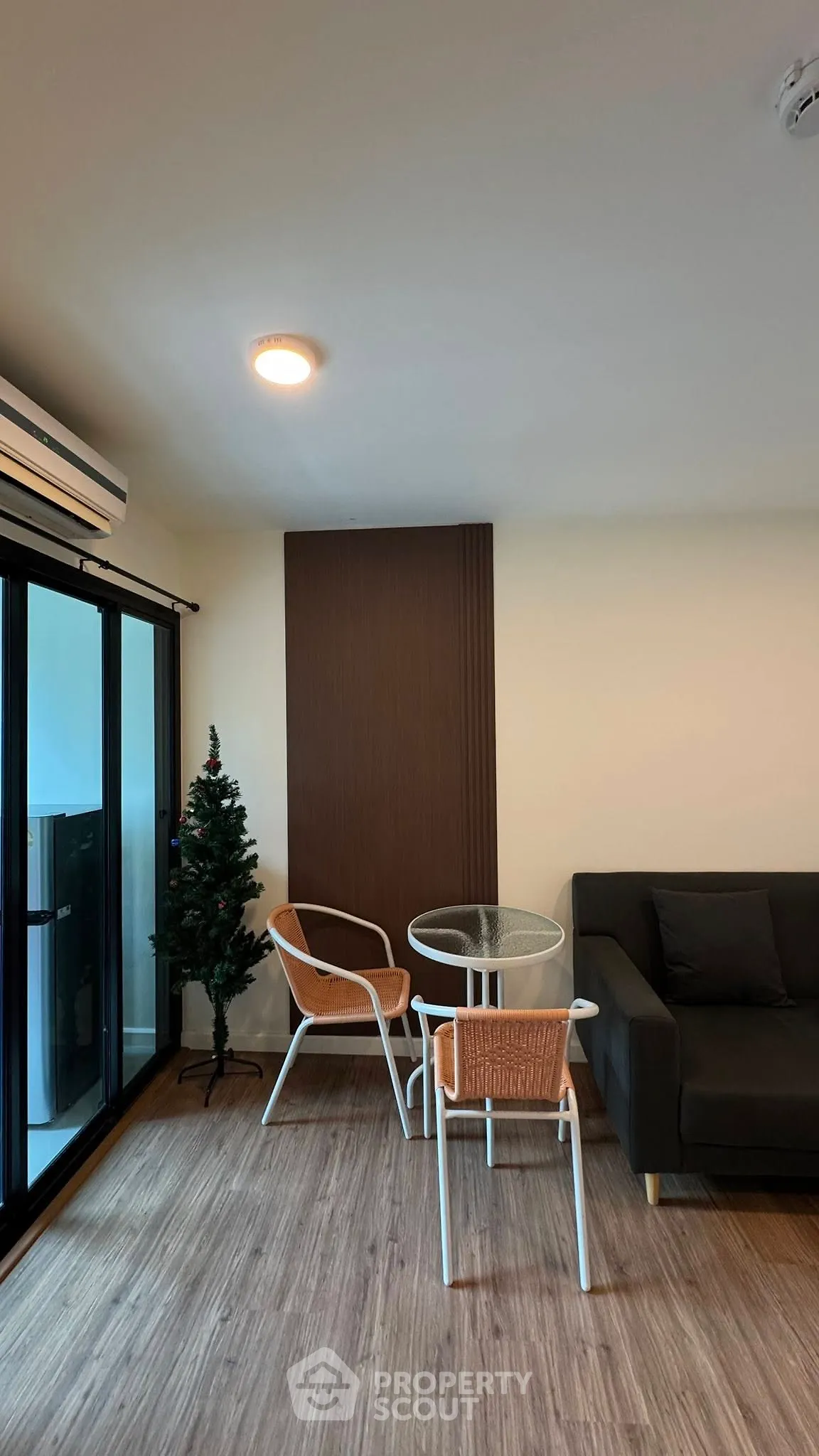 Modern living room with cozy seating and balcony access in a stylish apartment.