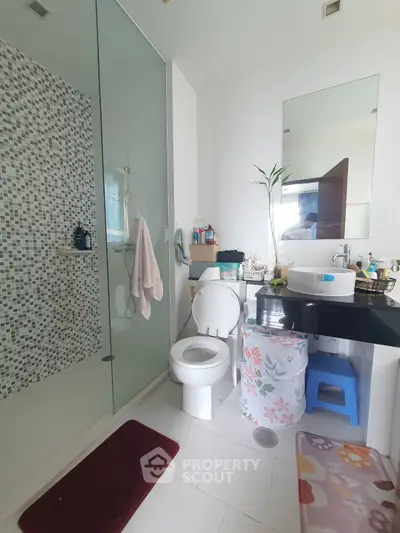 Modern bathroom with glass shower, sleek vanity, and stylish decor