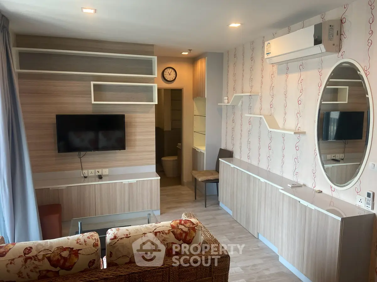 Modern living room with stylish decor, wall-mounted TV, and air conditioning in a cozy apartment.