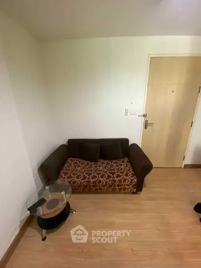 Cozy small living room with stylish sofa and glass side table