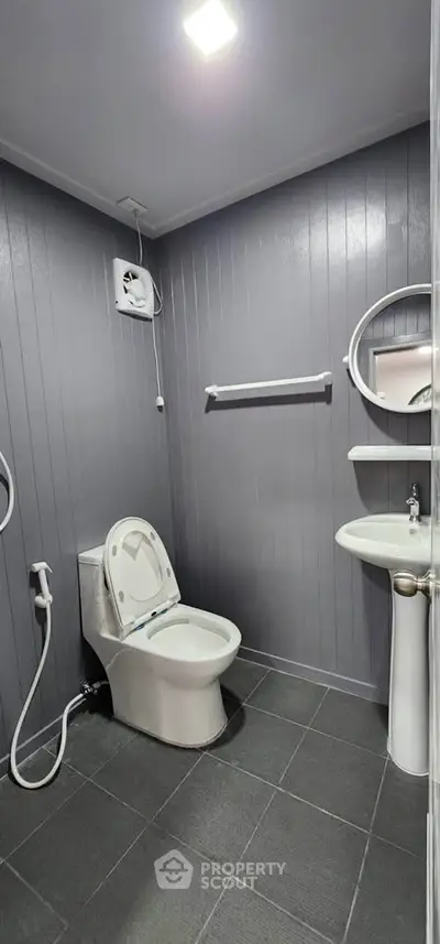Modern bathroom with sleek gray paneling and contemporary fixtures