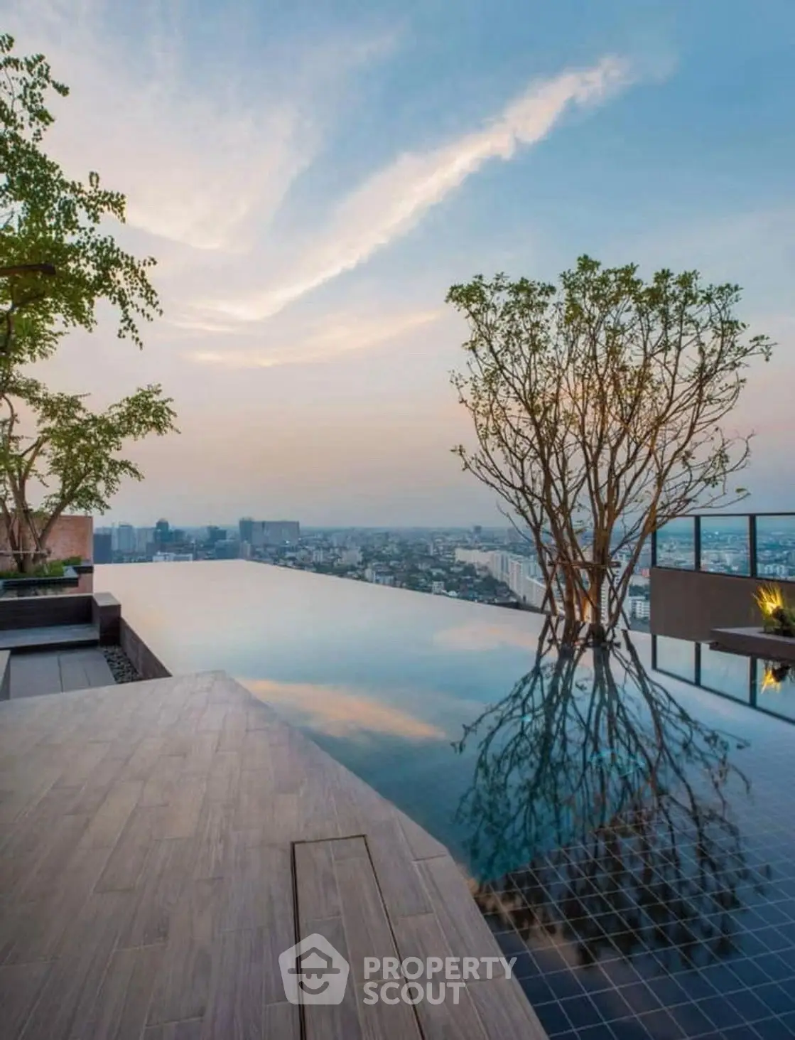 Stunning rooftop infinity pool with breathtaking city skyline view at sunset.