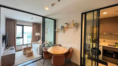 Modern apartment with open living and dining area, featuring stylish furniture and large windows.