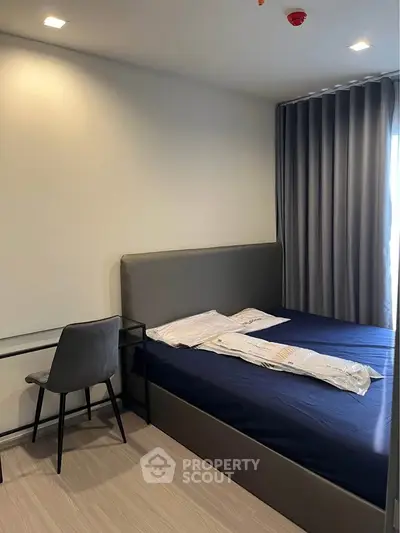 Modern bedroom with sleek furniture and natural light, perfect for a cozy living space.