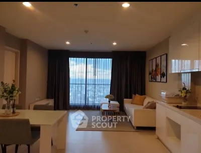 Spacious modern living room with city view, open kitchen, and elegant decor.