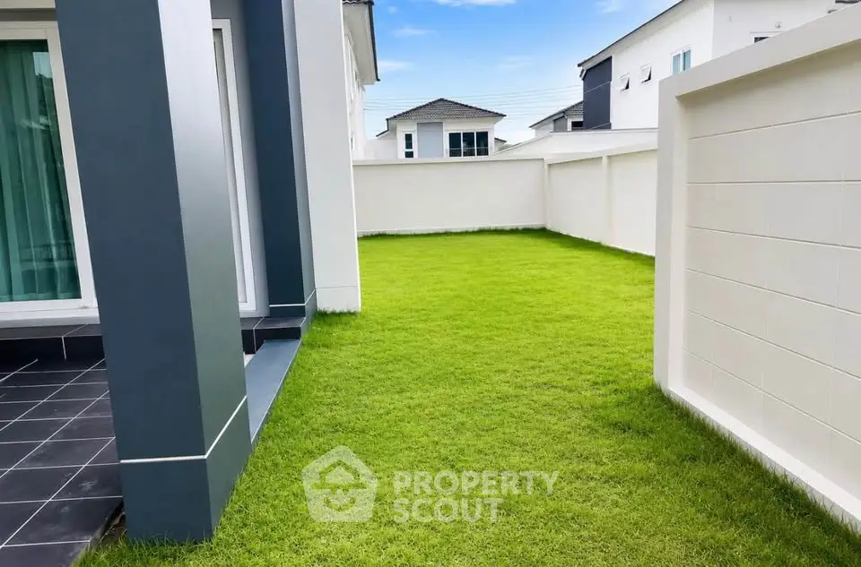 Spacious backyard with lush green lawn in modern residential property