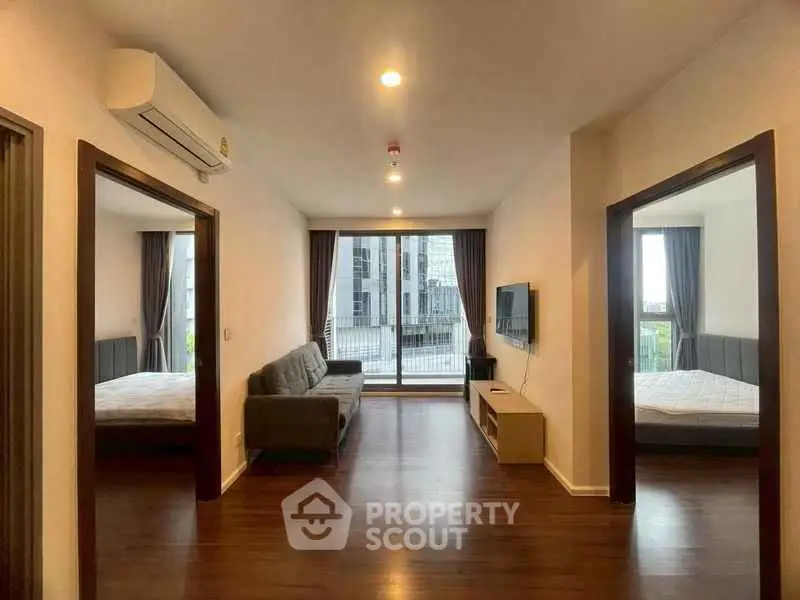 Spacious living room with modern decor and large windows in a stylish apartment.