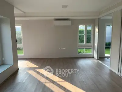 Spacious empty living room with large windows and garden view
