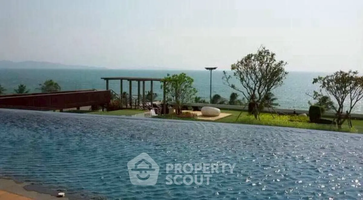 Luxurious oceanfront infinity pool with stunning sea view and lush garden area.