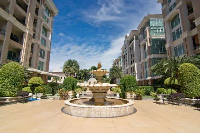 Luxurious condominium courtyard with elegant fountain and lush landscaping.