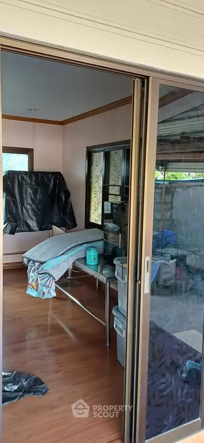 Cozy room with sliding glass door and wooden flooring, ideal for versatile use in a home setting.
