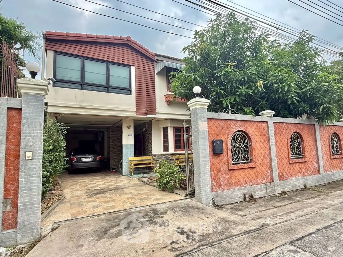 Charming two-story house with carport and gated entrance in a suburban neighborhood.
