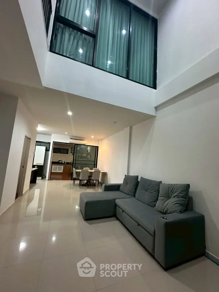 Spacious modern living room with high ceiling and sleek interior design