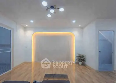 Modern living room with stylish lighting and wooden flooring, perfect for cozy gatherings.