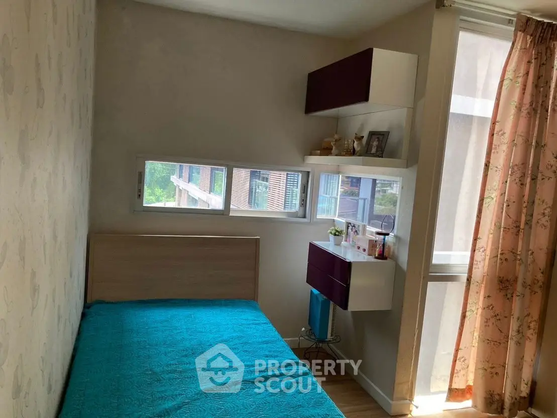 Cozy bedroom with natural light and modern shelving in urban apartment