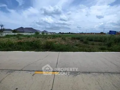 Vacant land plot with clear sky, ideal for development in a serene neighborhood.
