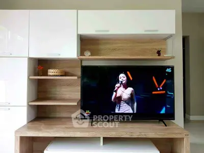 Modern living room with stylish TV unit and sleek wooden shelves.