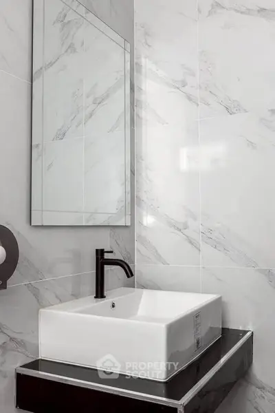 Modern bathroom with sleek white sink and marble wall tiles