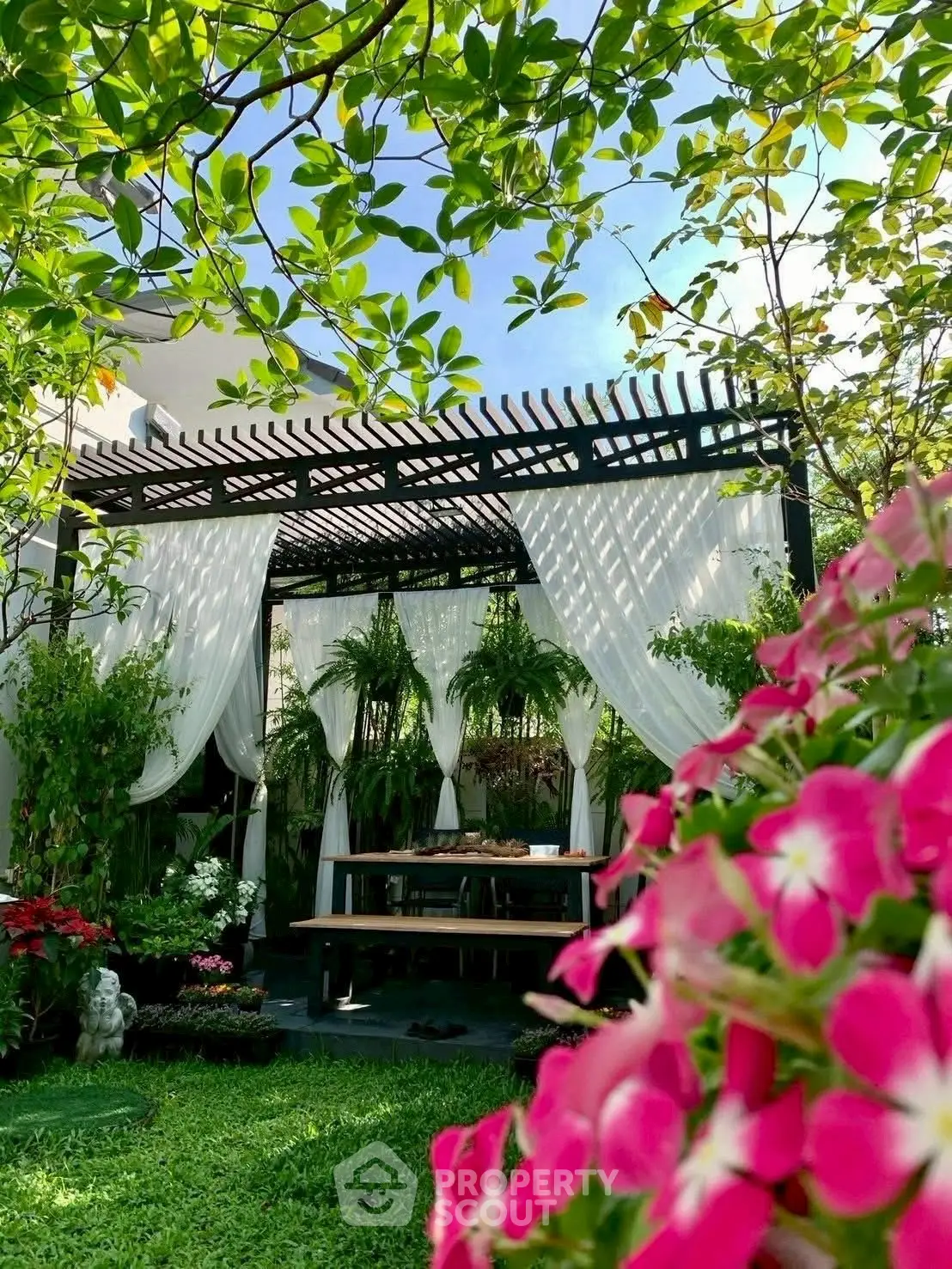 Charming garden with pergola and lush greenery, perfect for outdoor relaxation.