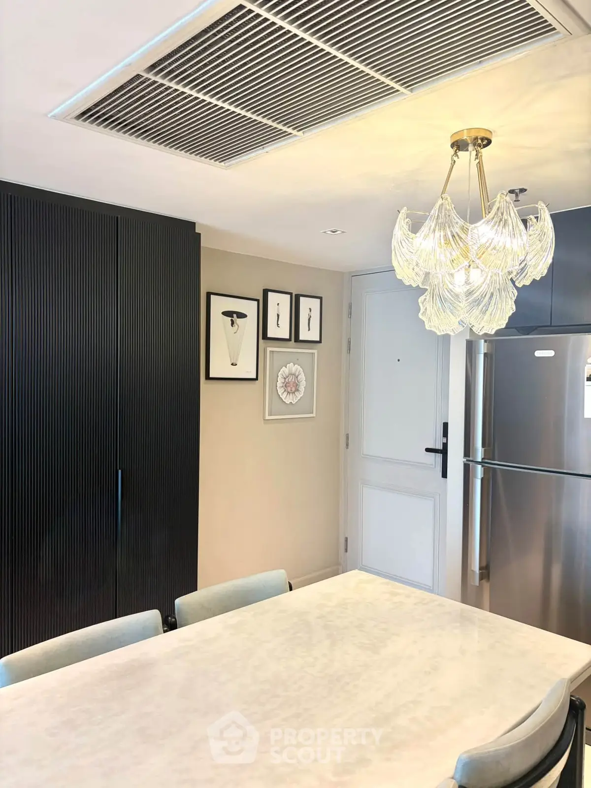 Modern kitchen with elegant chandelier and sleek appliances