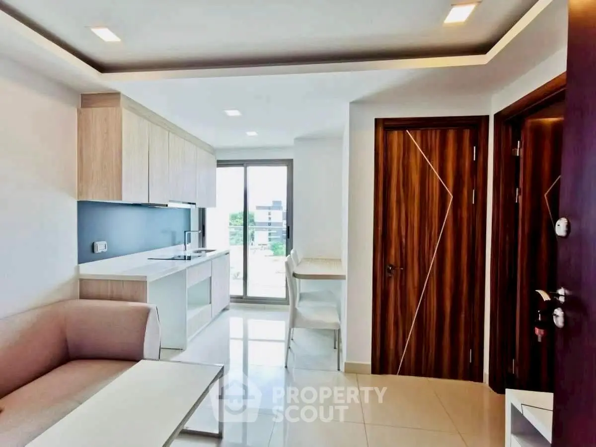 Modern open-layout living room with sleek kitchen and natural light