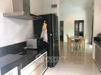 Modern kitchen with sleek black countertops and dining area in open layout