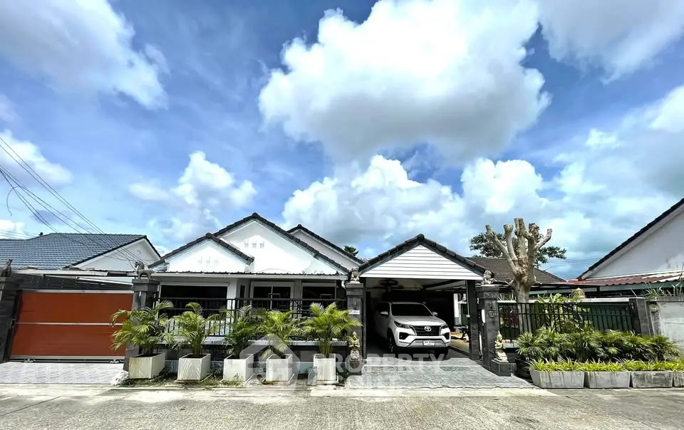 Charming suburban home with spacious driveway and lush greenery under a bright blue sky.