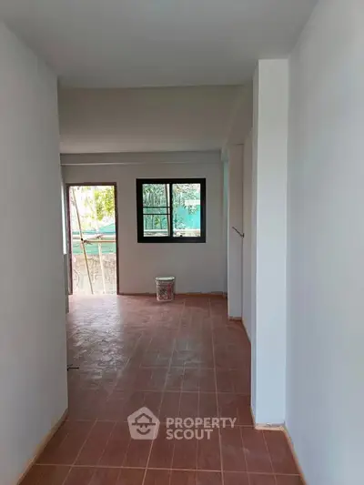 Spacious interior with tiled flooring and large windows offering natural light.