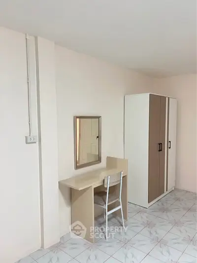 Minimalist bedroom with wardrobe, desk, and chair on tiled floor.
